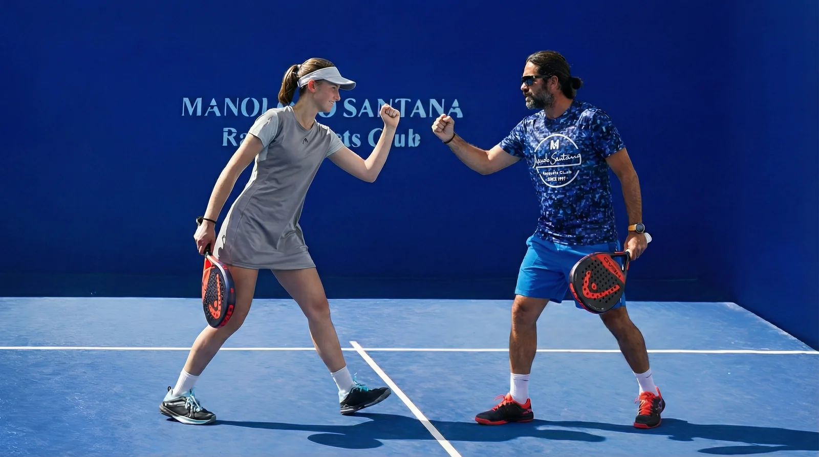 Pupil and coach bumping fists after a point
