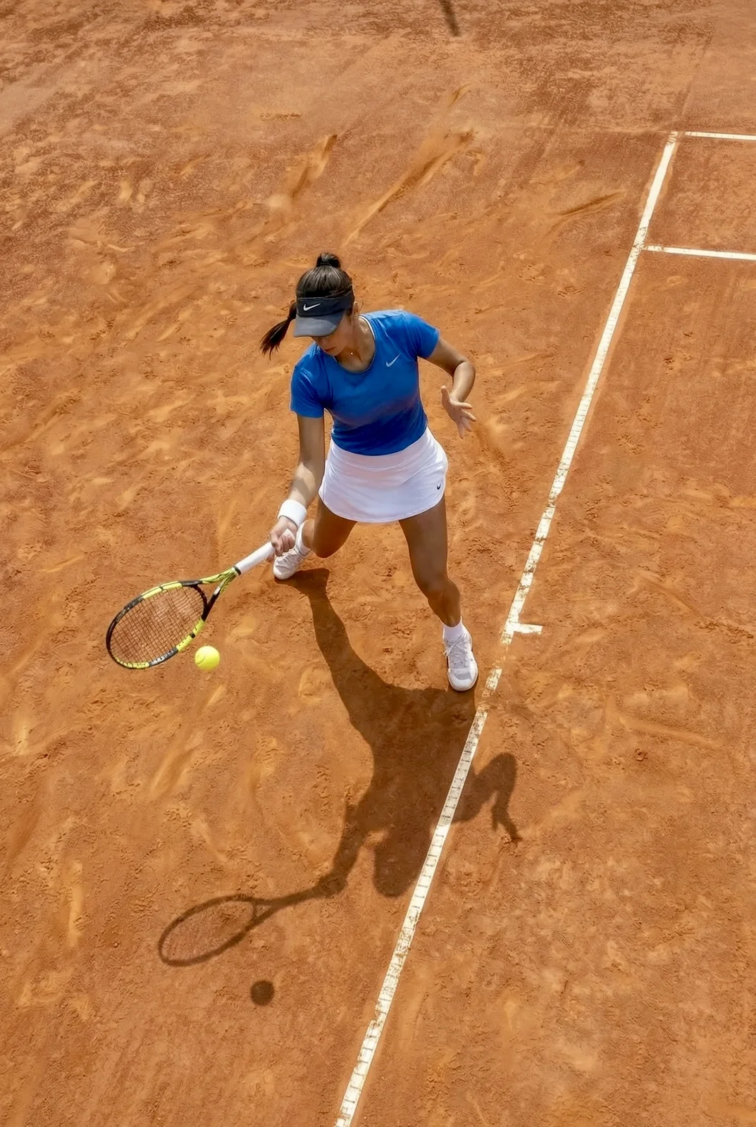 Top-down view of a player hitting on a clay court