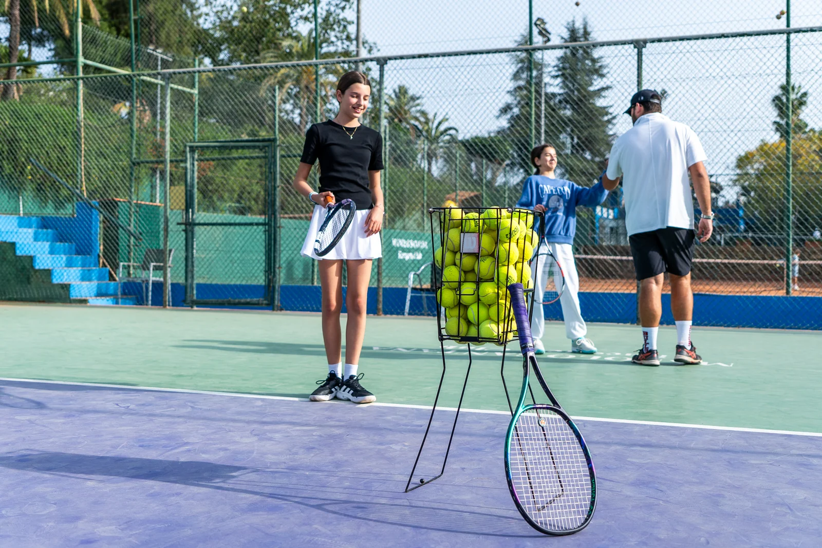 Coach high-fiving a student next to the ball basket