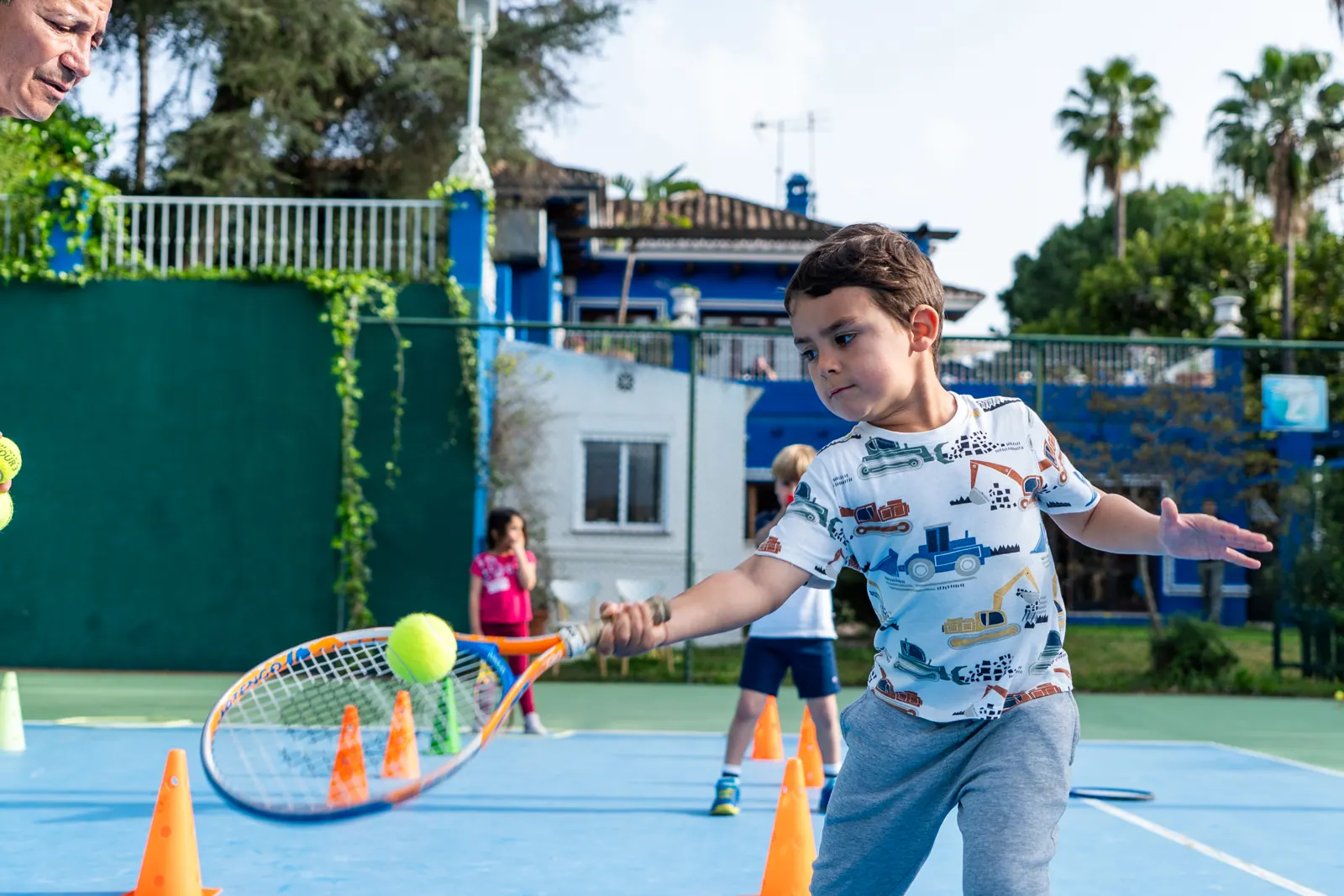Student hitting the ball in front of the clubhouse