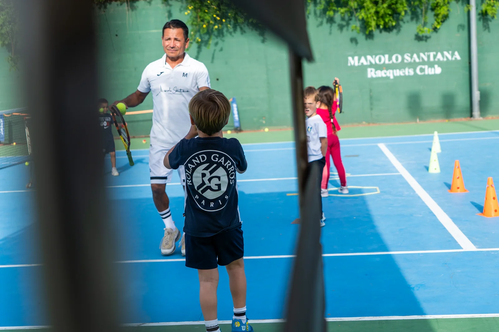 Coach with his group of students on the club blue court