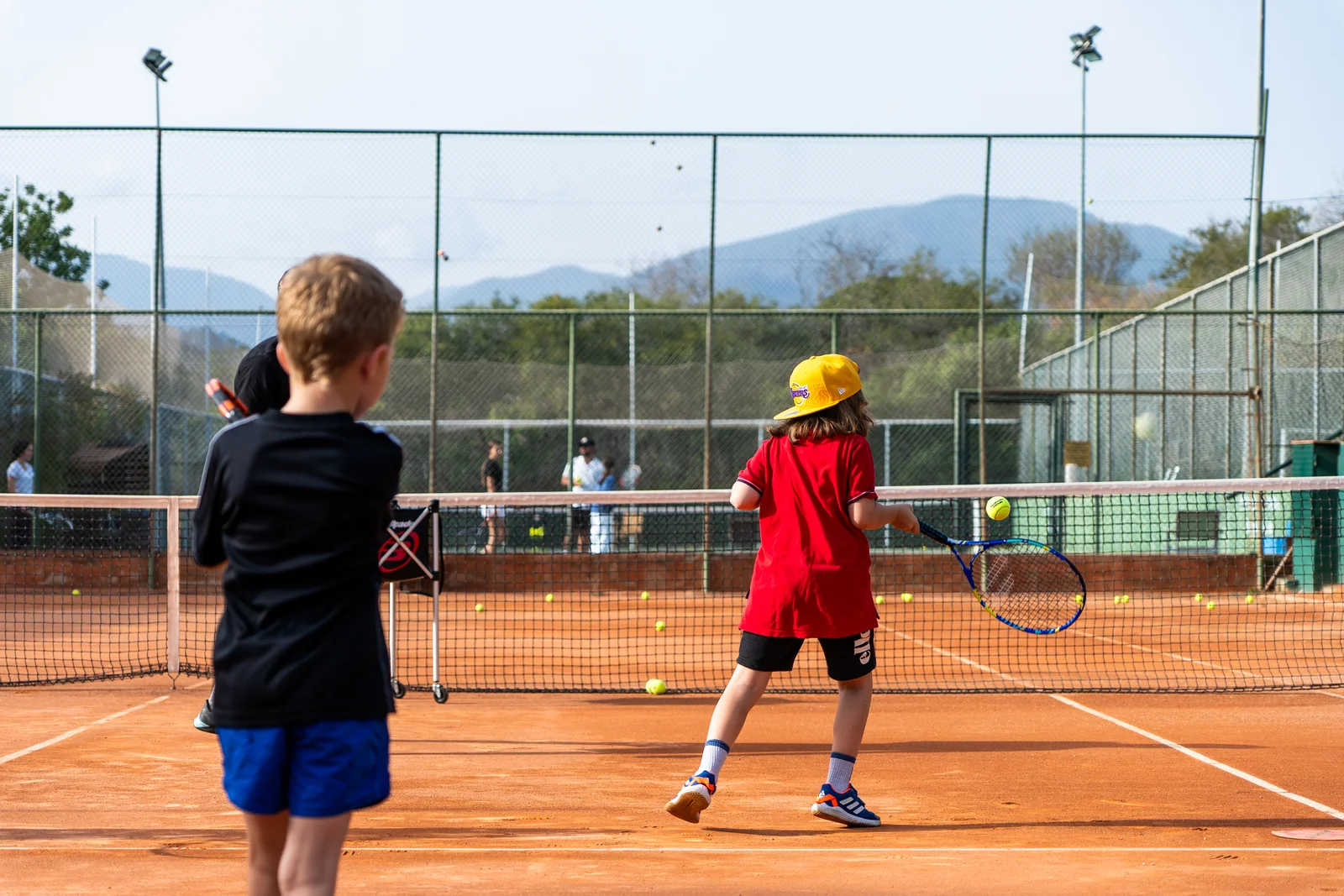 Students rallying on a clay court
