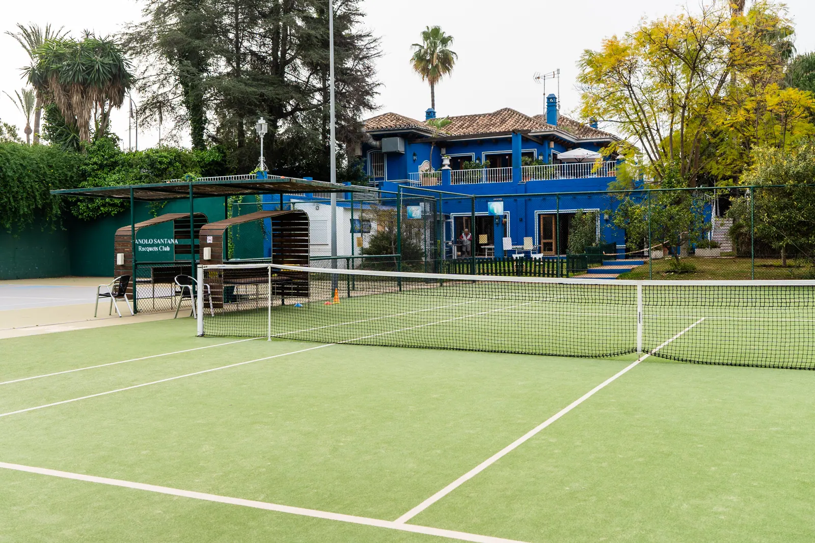Artificial grass court with the clubhouse behind